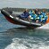 Guests wear wind proof jackets while riding on a rubber speed boat in the Finnish Archipelago